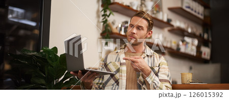 You got a point. Portrait of serious man agree with colleague, pointing finger at laptop screen, connects to video chat, has conversation with someone You got a point. Portrait of serious man agree with colleague, pointing finger at laptop screen, connects to video chat, has conversation with someone 126015392