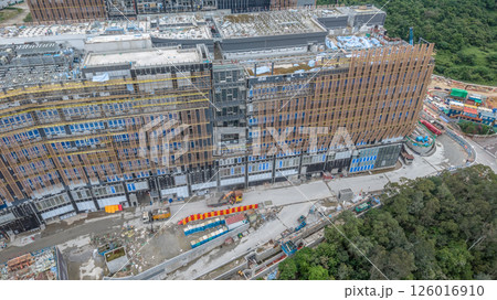 MAY 10 2025 View of a Large Urban Construction Site Amid Surrounding Greenery 126016910