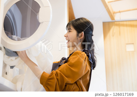 ドラム式洗濯機から洗濯物を取り出す女性 126017169