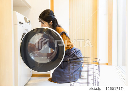 ドラム式洗濯機から洗濯物を取り出す女性 126017174