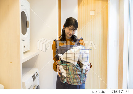 ドラム式洗濯機から洗濯物を取り出す女性 126017175