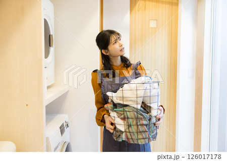 ドラム式洗濯機から洗濯物を取り出す女性 126017178