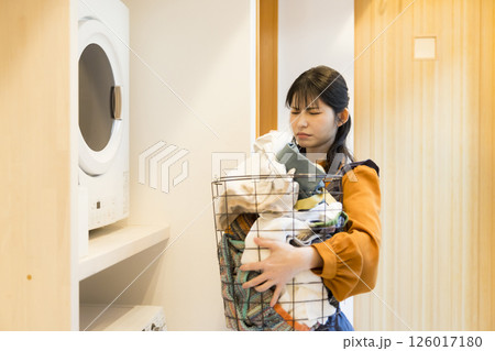 ドラム式洗濯機から洗濯物を取り出す女性 ドラム式洗濯機から洗濯物を取り出す女性 126017180