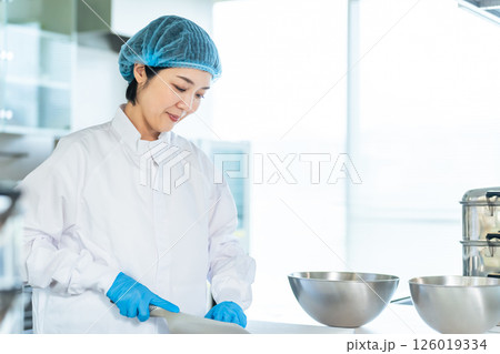 厨房で料理する衛生白衣を着た女性調理師　給食センター　給食室 126019334