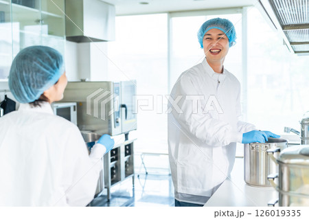 厨房で大鍋で調理する衛生白衣を着た男性調理師　給食センター　給食室 126019335