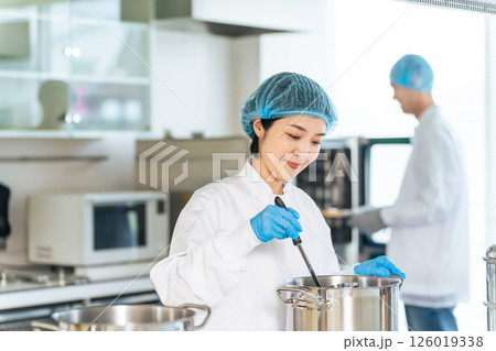 厨房で大鍋で調理する衛生白衣を着た女性調理師 給食センター 給食室 厨房で大鍋で調理する衛生白衣を着た女性調理師 給食センター 給食室 126019338