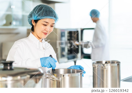 厨房で大鍋で調理する衛生白衣を着た女性調理師 給食センター 給食室 厨房で大鍋で調理する衛生白衣を着た女性調理師 給食センター 給食室 126019342