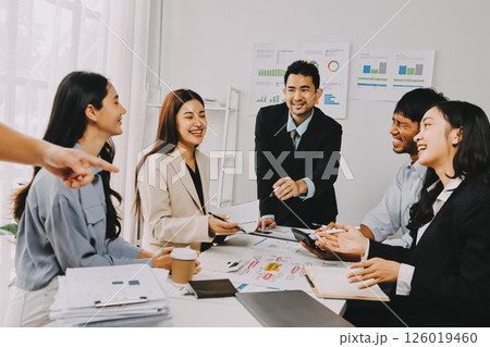 Team of financial advisory services. Asian advisor showing plan of investment to clients in the consultancy office. 126019460