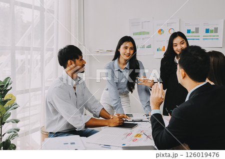 Team of financial advisory services. Asian advisor showing plan of investment to clients in the consultancy office. 126019476