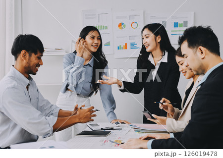 Team of financial advisory services. Asian advisor showing plan of investment to clients in the consultancy office. 126019478