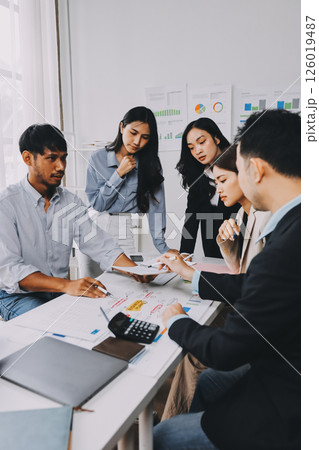 Team of financial advisory services. Asian advisor showing plan of investment to clients in the consultancy office. 126019487