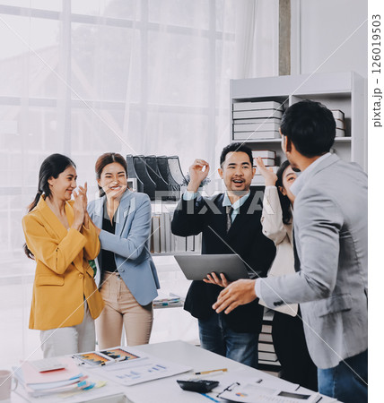 Group of Young Asian business team creative businesspeople coworker in office Happy to be successful partnership teamwork celebrating achievement and success concept. 126019503