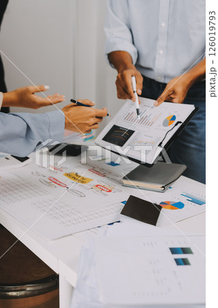 Team of financial advisory services. Asian advisor showing plan of investment to clients in the consultancy office. 126019793