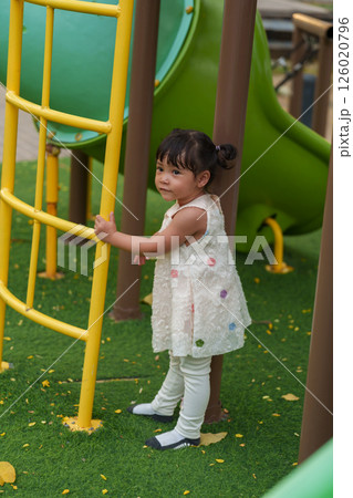 happy toddler girl playing at a outdoor playground in park 126020796