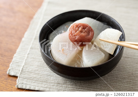 黒い器に入れた梅流し　箸で大根を持つ 126021317