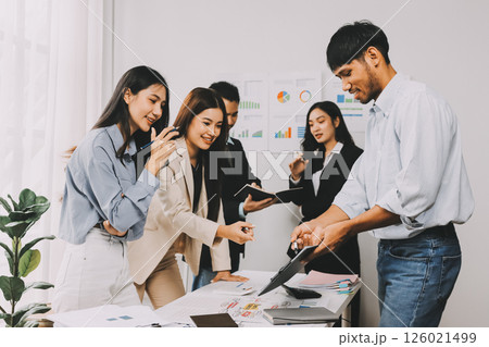 Team of financial advisory services. Asian advisor showing plan of investment to clients in the consultancy office. 126021499
