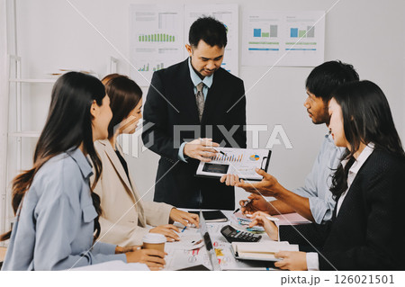 Team of financial advisory services. Asian advisor showing plan of investment to clients in the consultancy office. 126021501