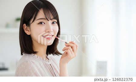 写真風素材:リップグロスを塗る女性(左寄り) 写真風素材:リップグロスを塗る女性(左寄り) 126022370