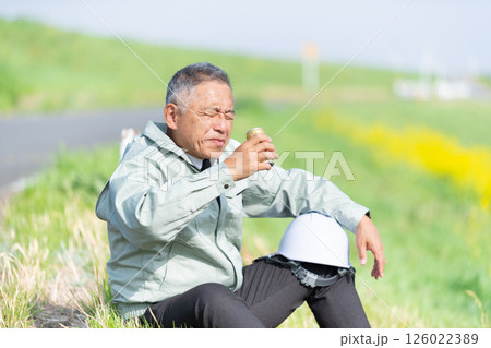 缶コーヒーを片手に休憩するシニア監督者 126022389