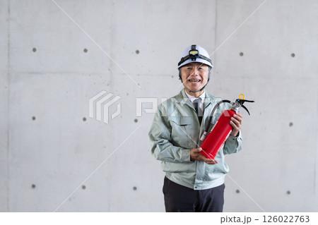 消火器を手に安全対策を呼びかける中高年男性 消火器を手に安全対策を呼びかける中高年男性 126022763
