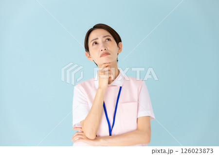 エプロンの女性　介護士　保育士　医療　悩む 126023873