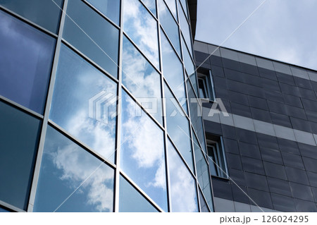 The sky beautifully reflects in the windows of a tall building The sky beautifully reflects in the windows of a tall building 126024295
