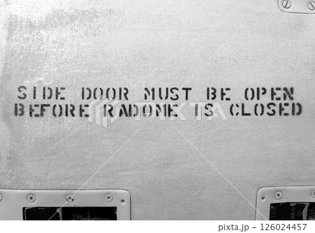 Aircraft fuselage with black stencil warning about radome closure 126024457