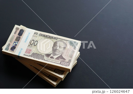 黒いテーブルに置かれた一万円札の札束 126024647