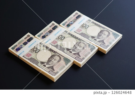 黒いテーブルに置かれた一万円札の札束 126024648