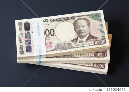 黒いテーブルに置かれた一万円札の札束 126024651