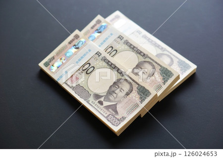 黒いテーブルに置かれた一万円札の札束 黒いテーブルに置かれた一万円札の札束 126024653
