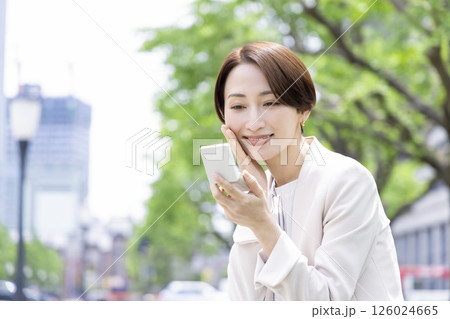 ビジネス　ベンチに座ってメイク直しをする女性 126024665