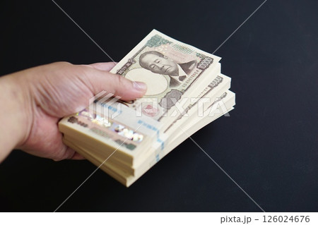 一万円札の札束を手に持つ瞬間 126024676