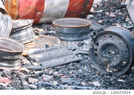 A pile of rusted and broken car parts, including a tire A pile of rusted and broken car parts, including a tire 126025054