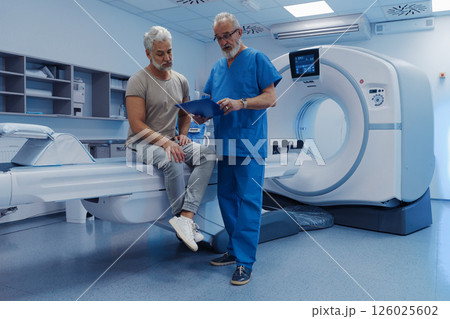 Doctor explaining CT scan results to patient in hospital setting Doctor explaining CT scan results to patient in hospital setting 126025602