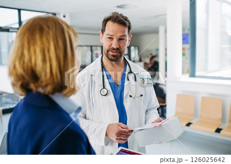 Female medical sales representative presenting medication to doctor Female medical sales representative presenting medication to doctor 126025642