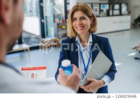 Pharmaceutical rep meeting with healthcare professional to discuss new drugs Pharmaceutical rep meeting with healthcare professional to discuss new drugs 126025646
