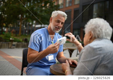 Doctor explaining medication to senior patient and answering her questions. Doctor explaining medication to senior patient and answering her questions. 126025826