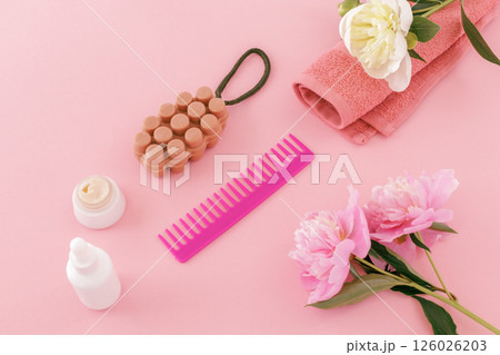 Towel with body care products and peony flowers on the pink background. Towel with body care products and peony flowers on the pink background. 126026203