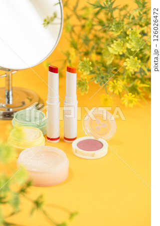 黄色背景に配置したリップスティックと補正カラー下地クリームとパウダーと鏡 黄色背景に配置したリップスティックと補正カラー下地クリームとパウダーと鏡 126026472