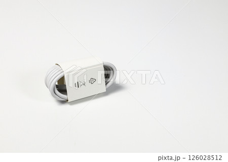 New white USB type charger cable, compatible for many devices, wrapped in a spiral shape, isolated on white background. New white USB type charger cable, compatible for many devices, wrapped in a spiral shape, isolated on white background. 126028512