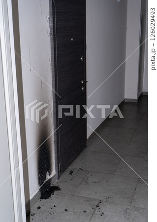 Arson of the front door of the apartment. Consequences of the fire. Black soot on the wall. 126029493