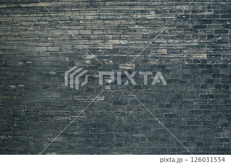 Dark gray brick wall forming a textured background 126031554