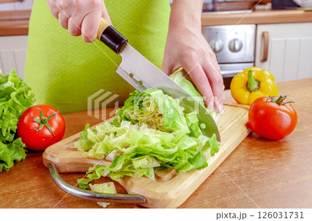 Woman chopping lettuce on cutting board... 126031731