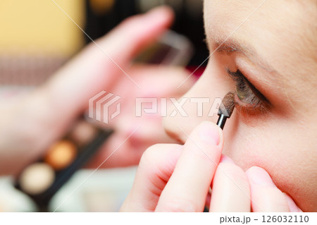 Close up woman getting make up, eyeshadow Close up woman getting make up, eyeshadow 126032110