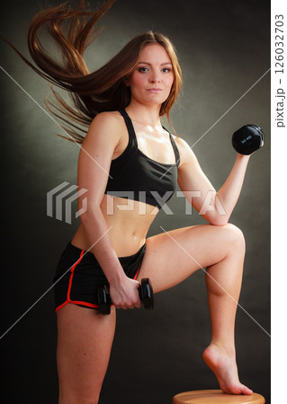 Fit woman exercising with dumbbells. 126032703