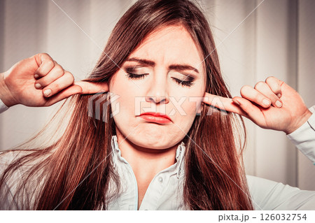 Stressed woman with closed eyes put fingers in ears, 126032754