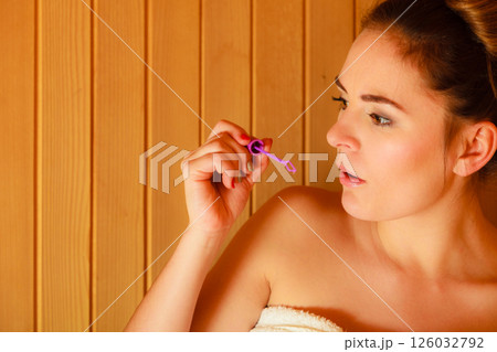 woman relaxing in sauna room blowing soap bubbles woman relaxing in sauna room blowing soap bubbles 126032792