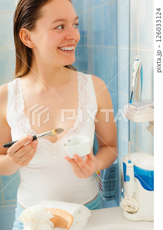 Woman applying mud facial mask Woman applying mud facial mask 126033124