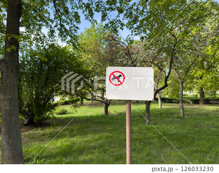 Minimalist no dogs allowed sign on white board placed in green public park with lush trees and lawn, emphasizing environmental care, pet restrictions and visual clarity in shared outdoor space Minimalist no dogs allowed sign on white board placed in green public park with lush trees and lawn, emphasizing environmental care, pet restrictions and visual clarity in shared outdoor space 126033230